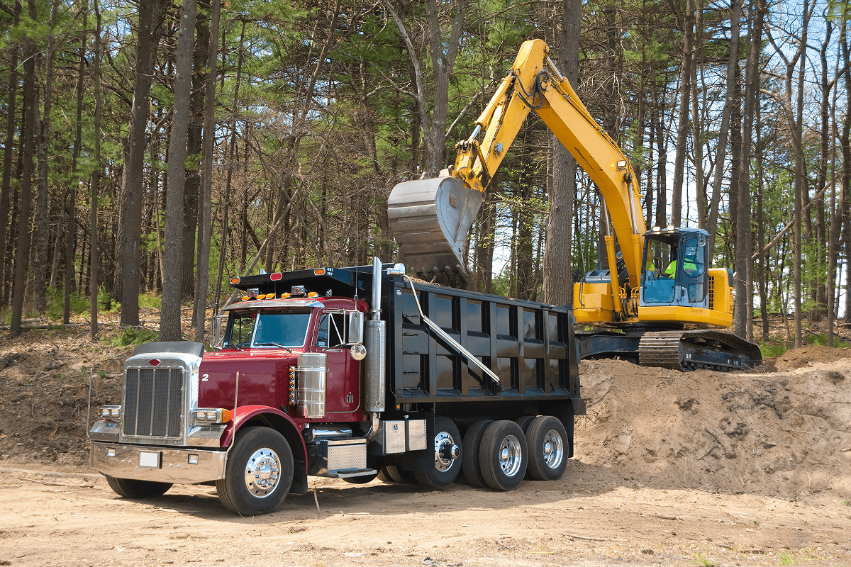 Excavator loading dirt into dump truck.