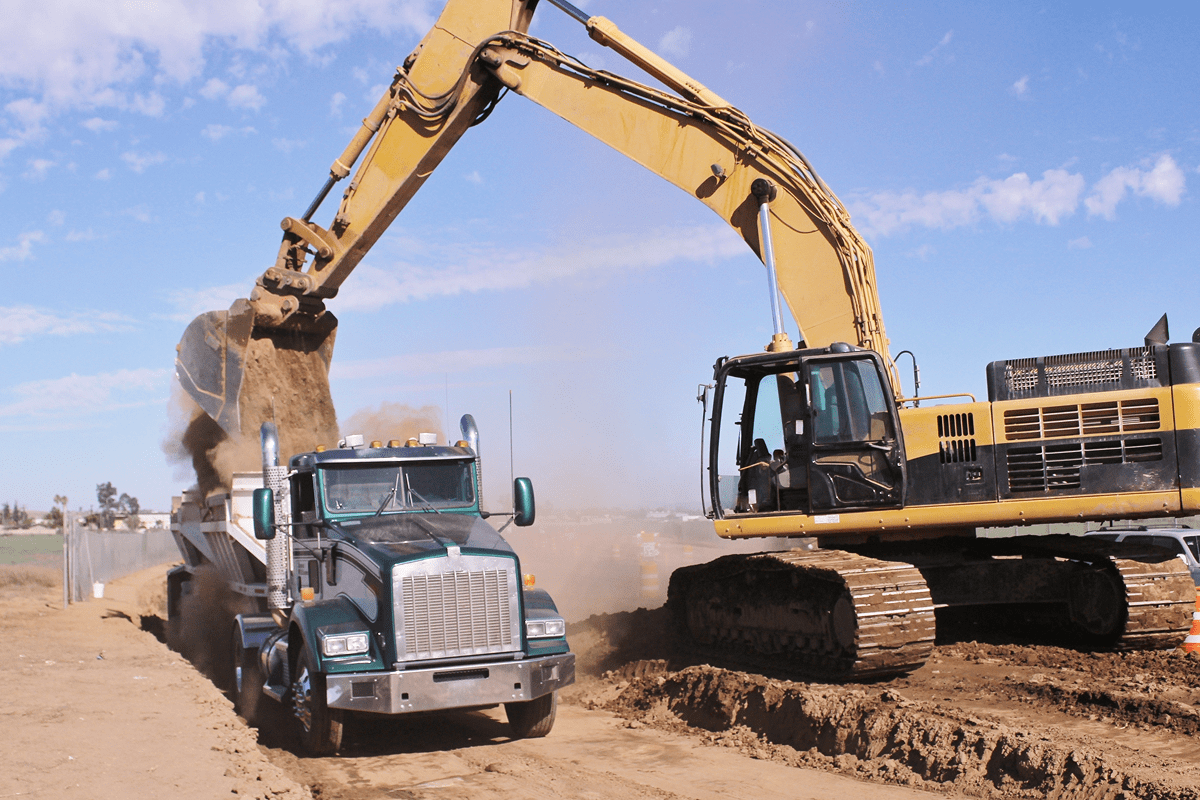 Excavator loading dirt into dump truck.